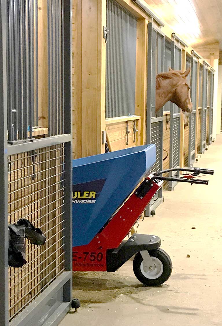 The Schweiss Electric Manure Hauler in a stall